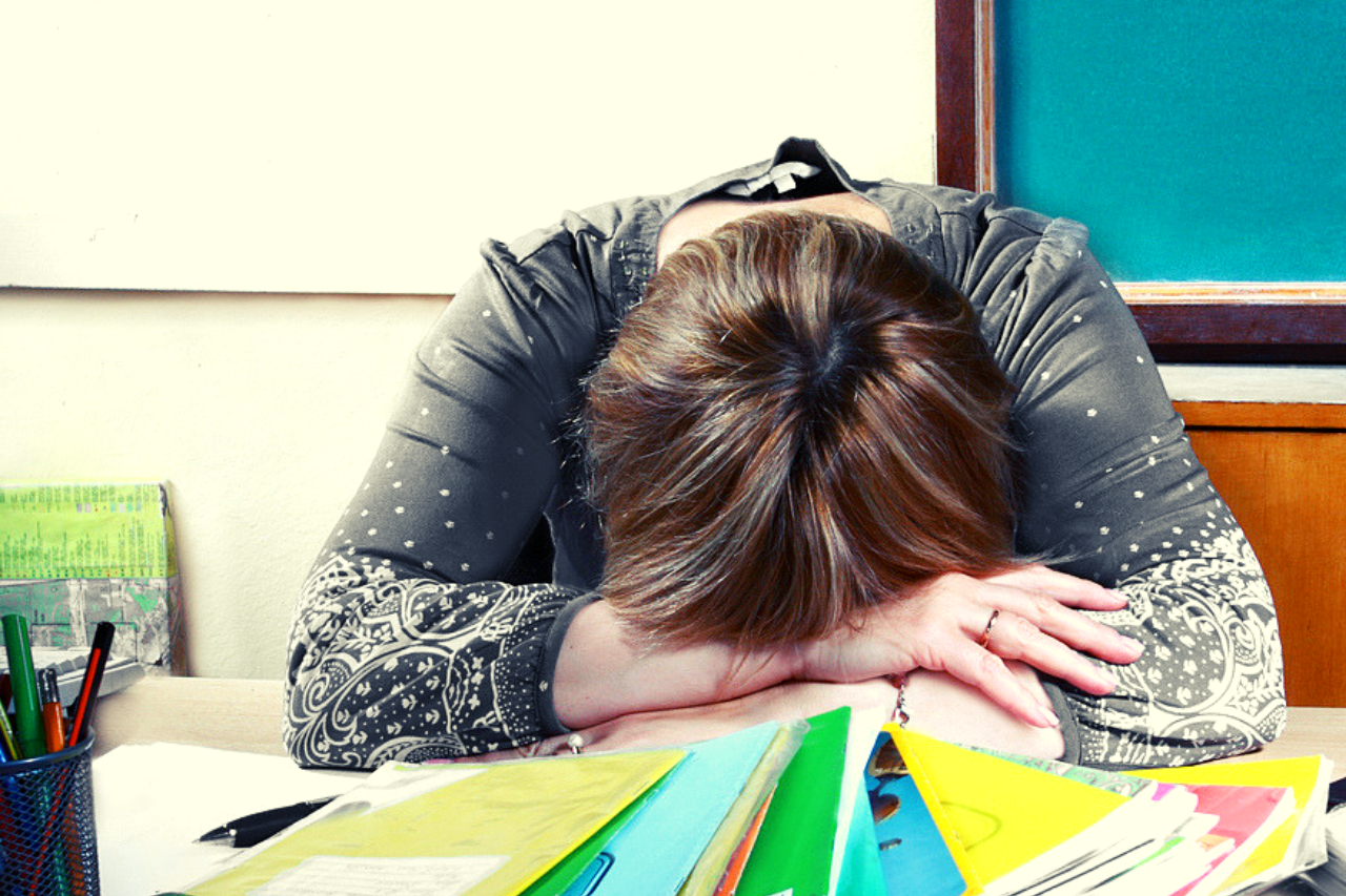 Teacher resting head on desk